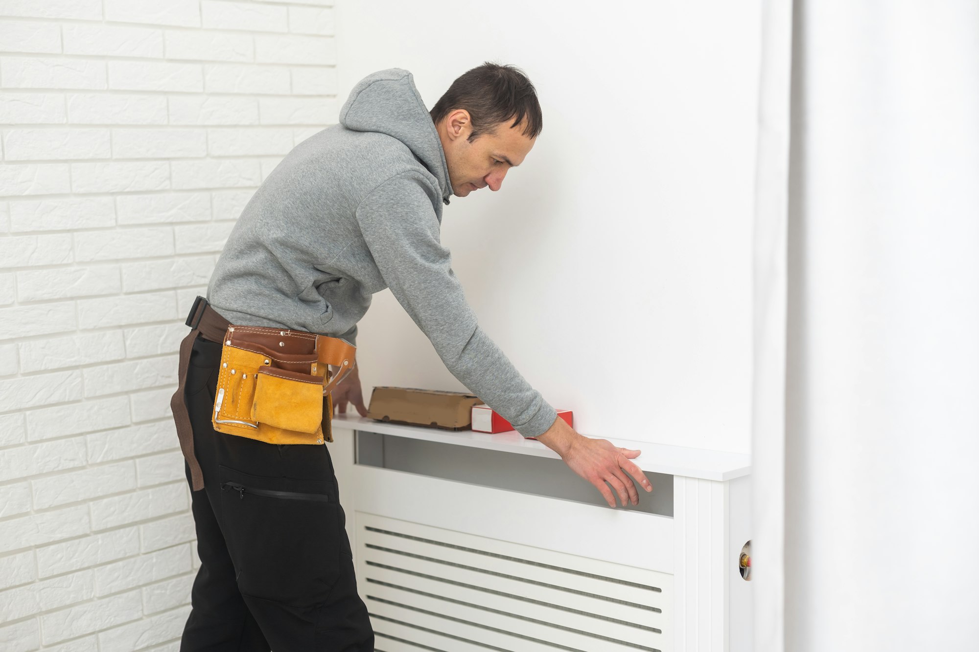 repairman using tools while installing or repairing heating radiator. plumber installing heating